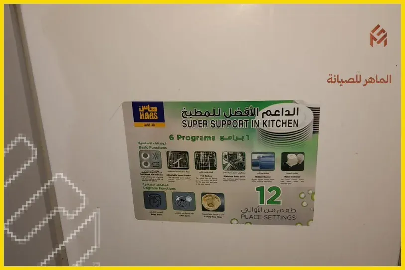 فني لابس ملابس زرقاء يقوم بفتح باب عسالة الصحون بدرل كهربائي