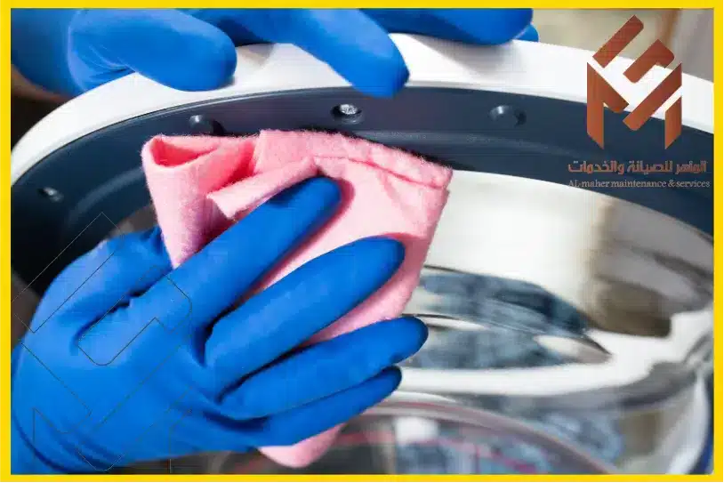 مهندس غسالات اتوماتيك بمكة بعمل صيانة دورية للغسالة للحفاظ على أداءها الأمثل تنظيف باب الغسالة بقماش وردي